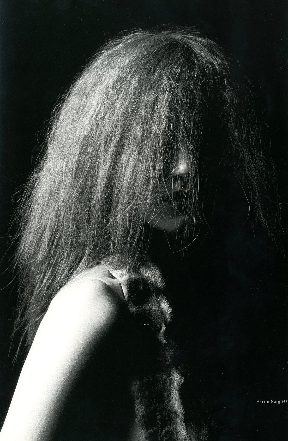 Black-and-white photograph from A Magazine N°A: model with long voluminous hair falling over the face, bare shoulder.