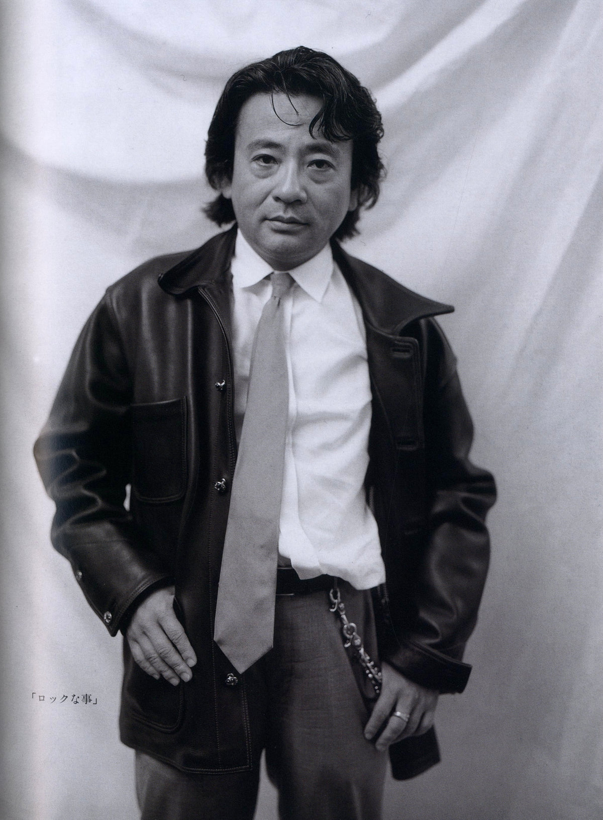 Black-and-white portrait of a man in a leather jacket, tie and wallet chain, Chrome Hearts Magazine Vol. 1.