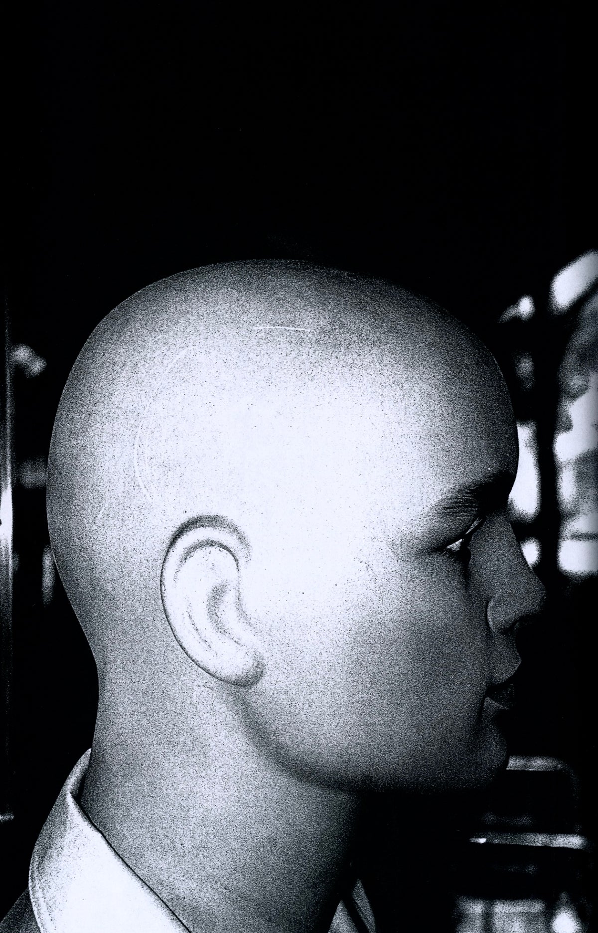 Bald mannequin head in profile against a black ground, Plastic Love, 2020.