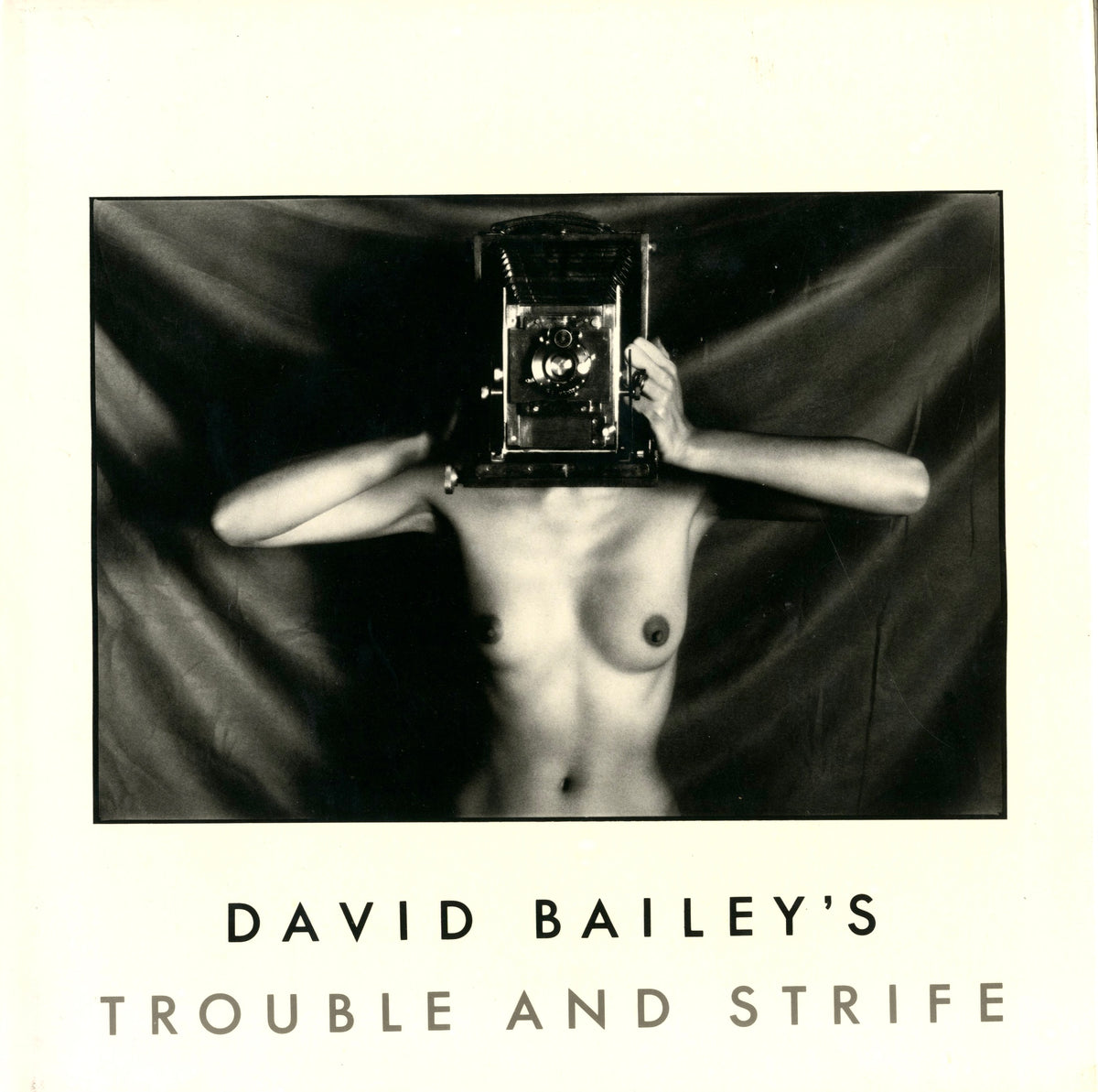 A lone figure lying on a deserted beach with islands on the horizon, plate from David Bailey’s Trouble and Strife.