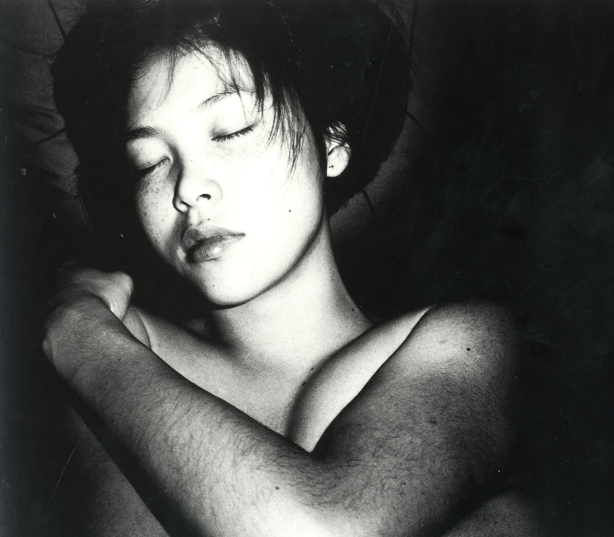 Black-and-white portrait from Hysteric Untitled: a young woman with eyes closed, arms crossed over her shoulders.
