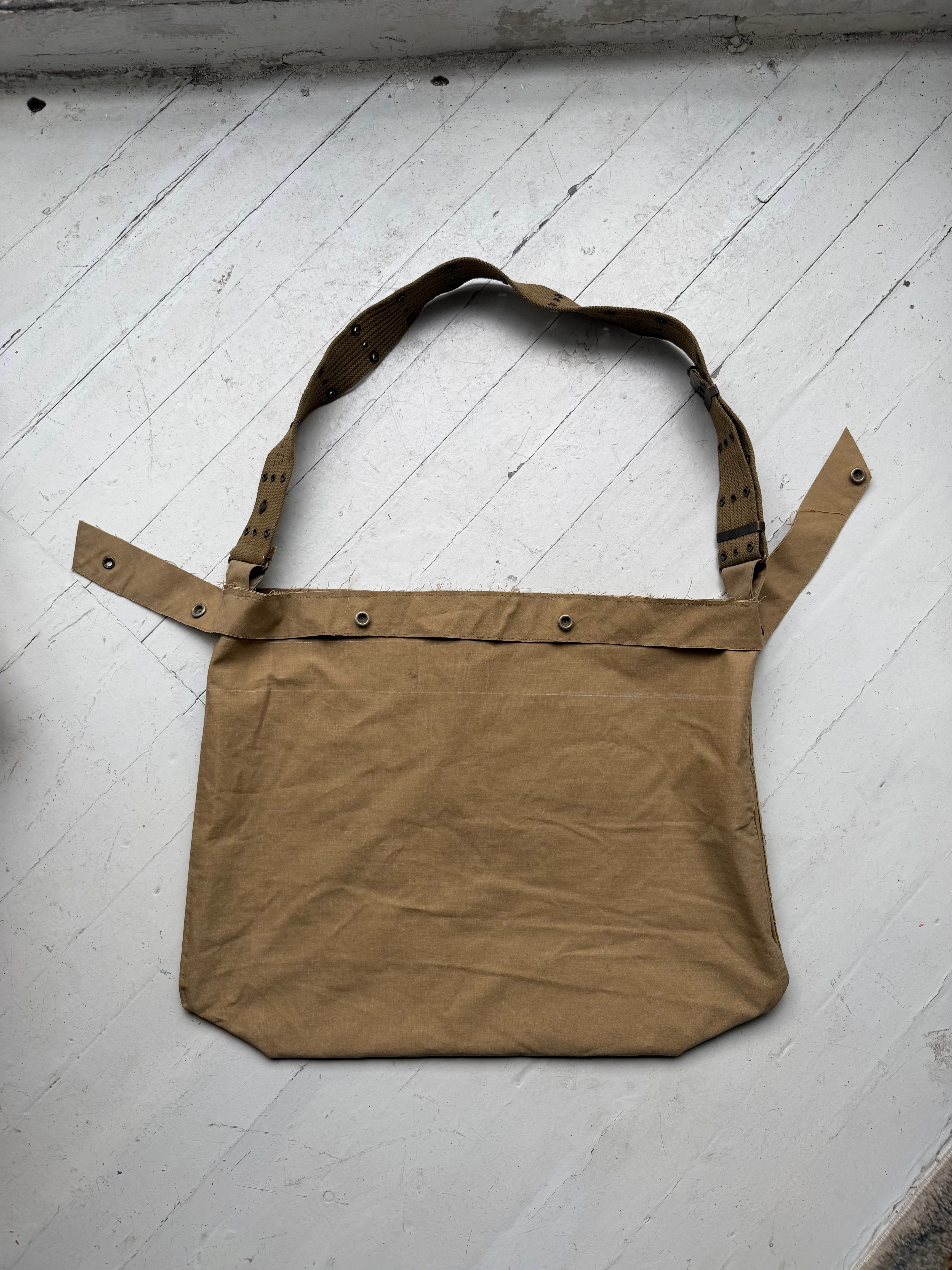 Khaki canvas tote by intermission laid flat, with a WWII M1936 web belt running across the top edge and forming the strap.