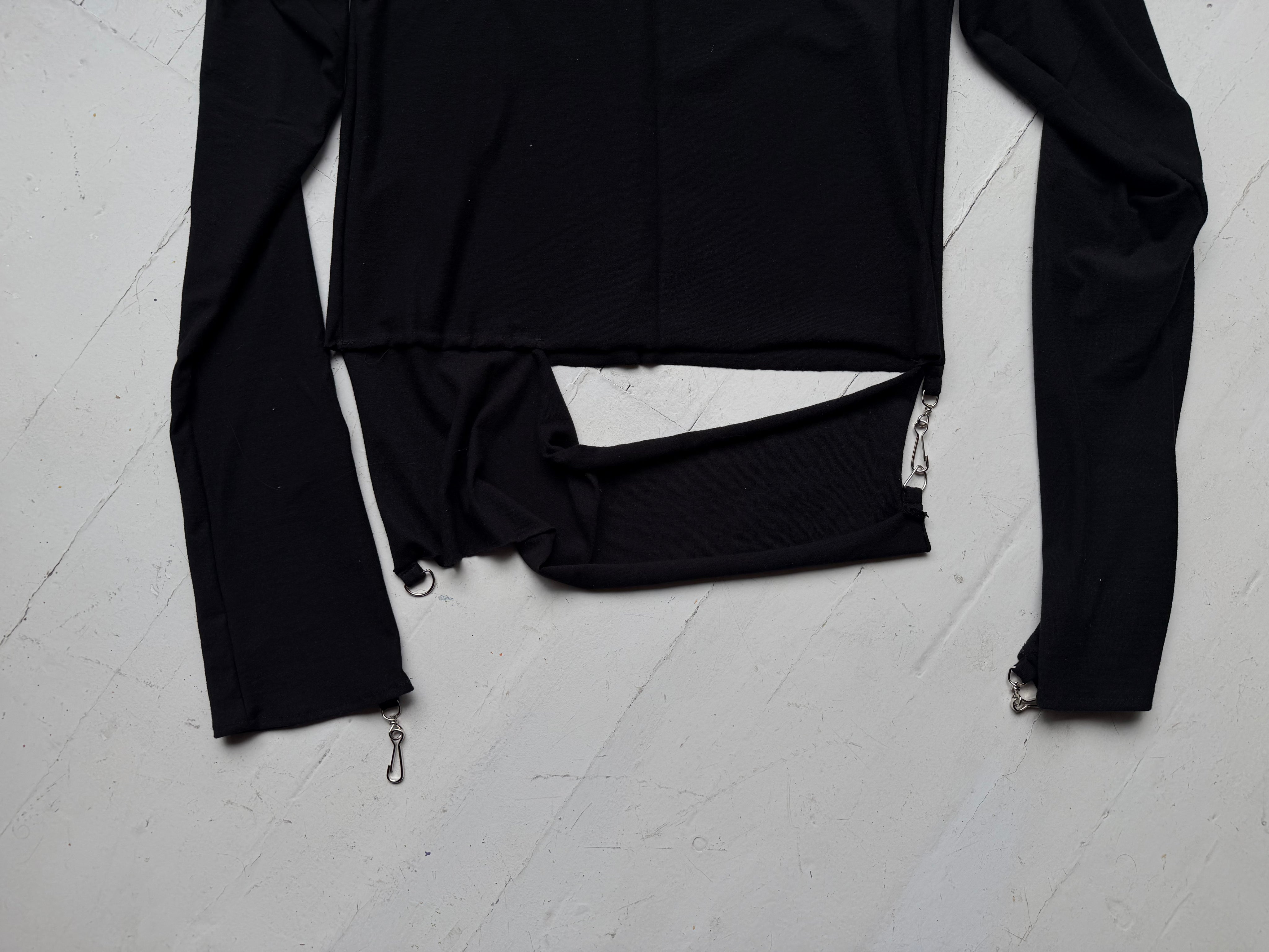 Detail of the split hem band and metal zip pull at the cuff of the intermission top.