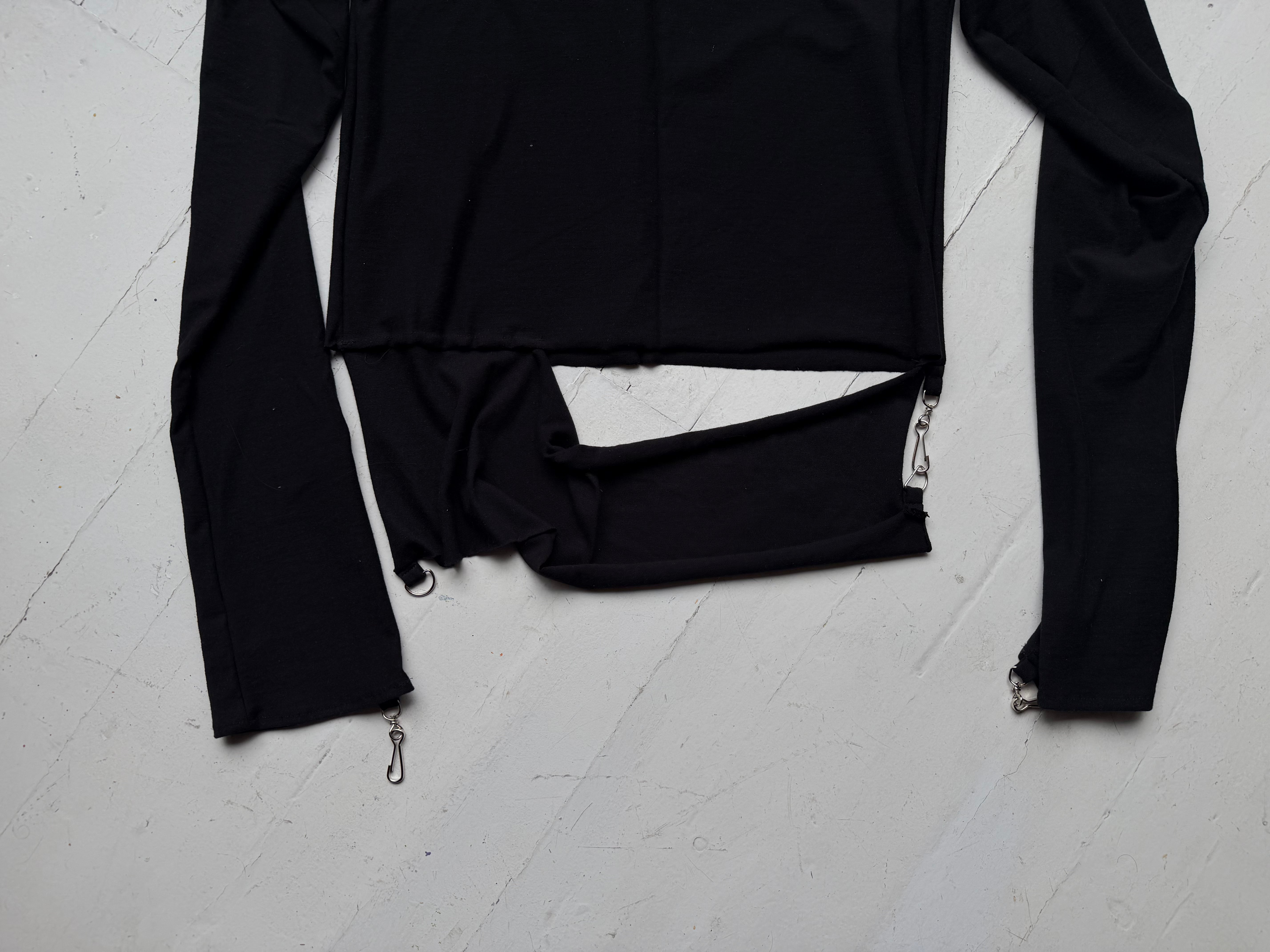 Detail of the split hem band and metal zip pull at the cuff of the intermission top.