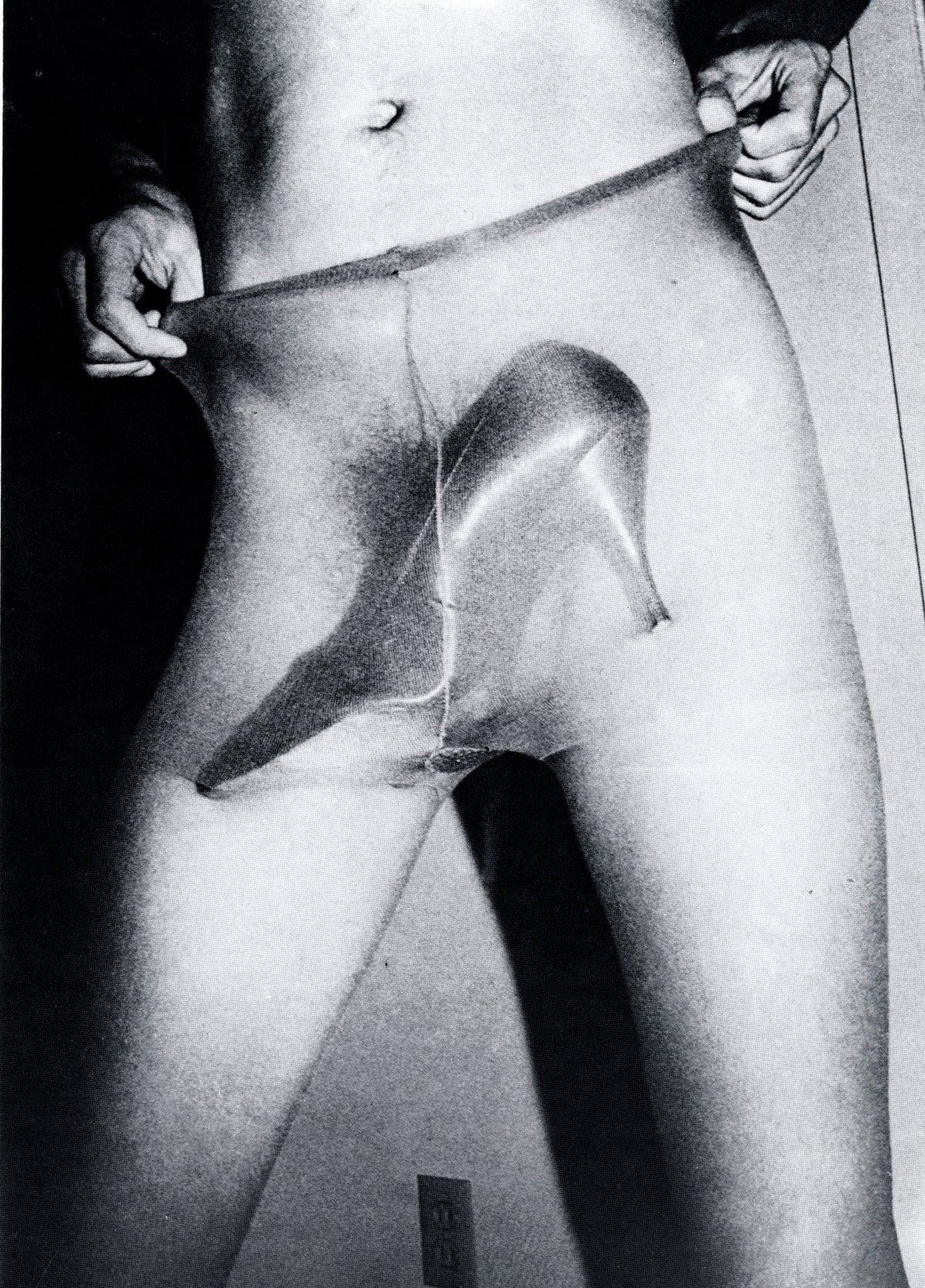 Jimmy DeSana photograph from Submission: torso and legs in sheer tights pulled to the waist, an object pressed beneath the fabric.