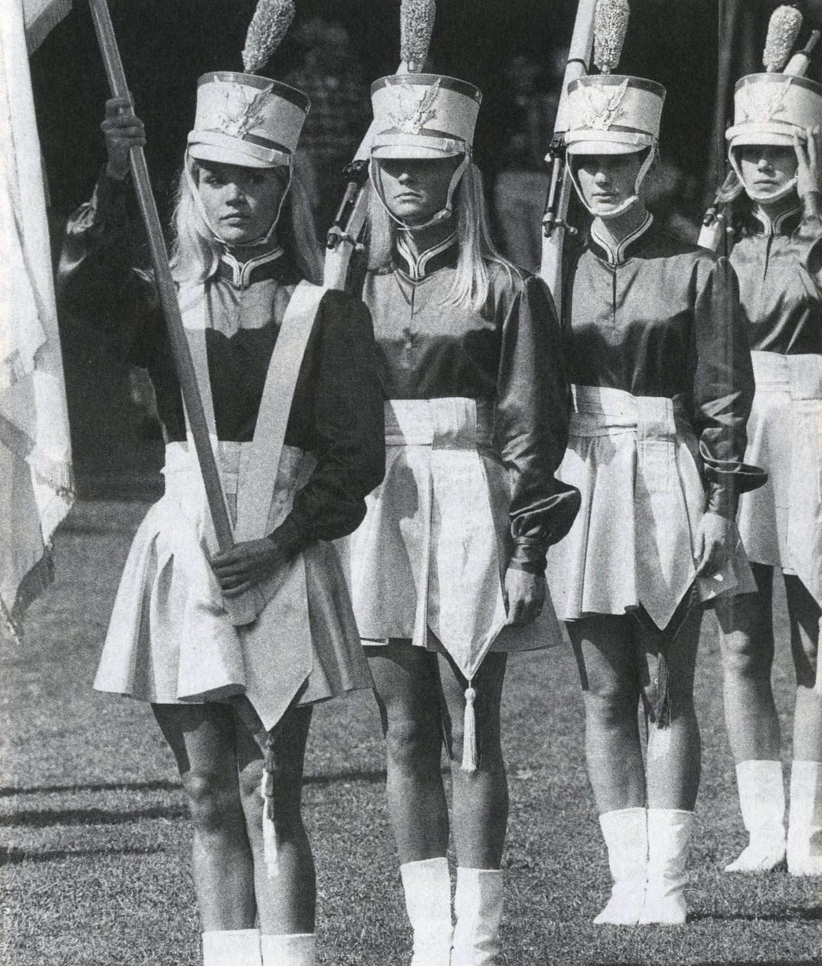 Black-and-white photograph of a line of majorettes in uniforms, caps and white boots, Fama & Fortune Heft 8.