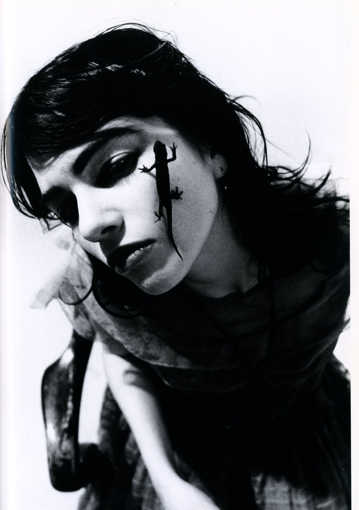 Young woman in a dark slip with one hand to her head in hard light, black-and-white plate from XX Girls.