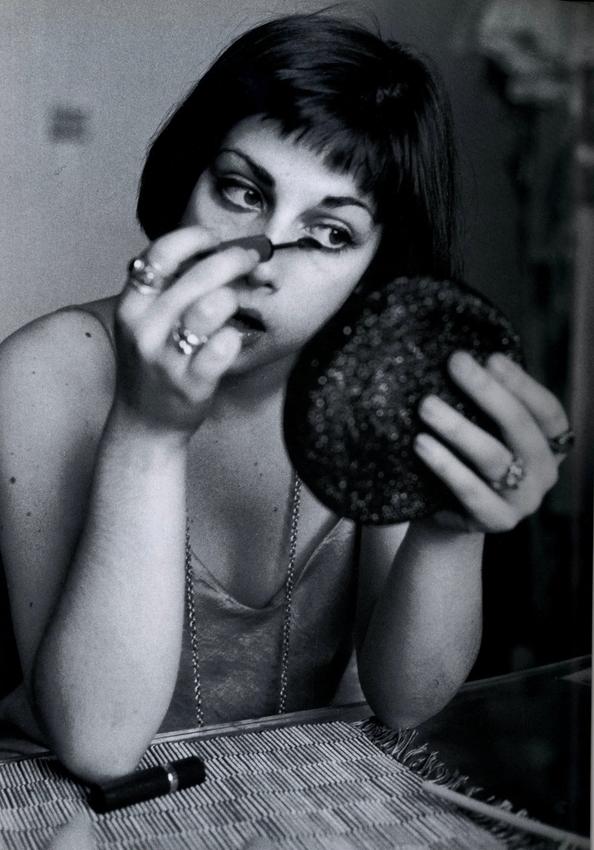Young woman in a lace top holding a powder puff to her face, black-and-white plate by Richard Kern.