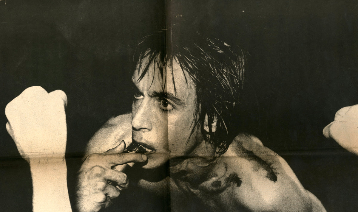Close-up black-and-white portrait from Search & Destroy No. 4: dark-haired singer biting his hand, fists raised.